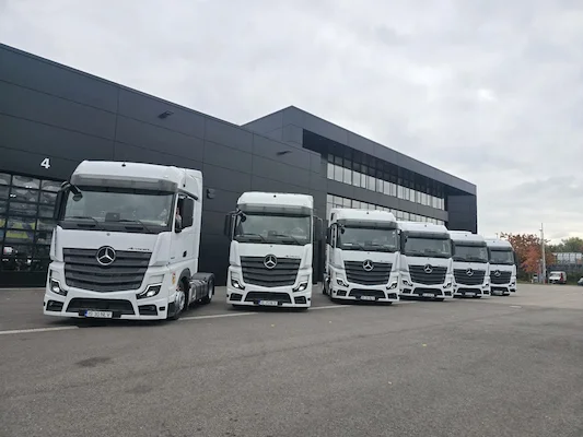 fleet of modern white freight trucks lined up at a European logistics company headquarters